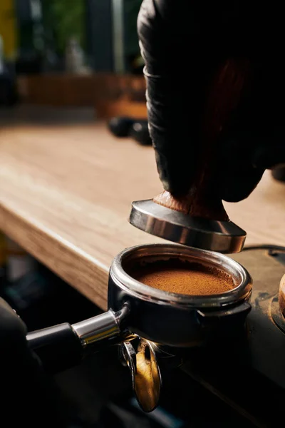 Barista hält Stampfer über Portafilter mit gemahlenem Kaffee, Espresso, Handpresse, Arabica — Stockfoto