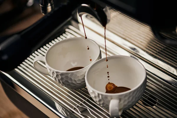 Extração de café, bebida quente, espresso gotejamento em copos, máquina de café profissional, café — Fotografia de Stock