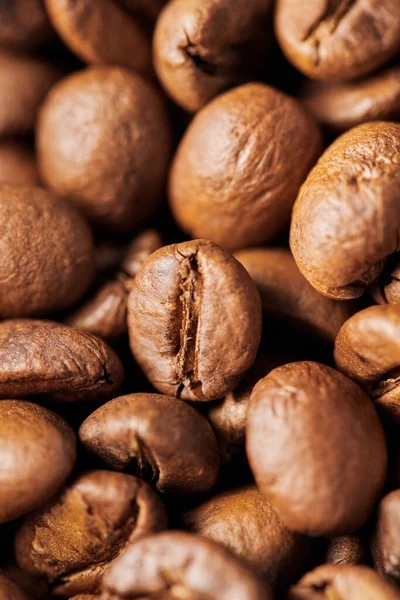Макро, коричневые кофейные зерна в деревянной коробке, среднее жаркое, кофеин и энергия, кофейный фон — стоковое фото