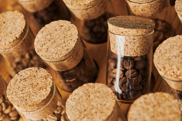 Grains de café dans des bocaux en verre avec liège, torréfié, caféine et énergie, fond de café, vue de dessus — Photo de stock