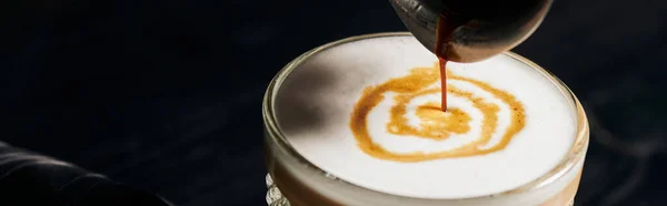 Latte macchiato, verter espresso en vidrio, jarra con café, espuma de leche, energía, pancarta - foto de stock