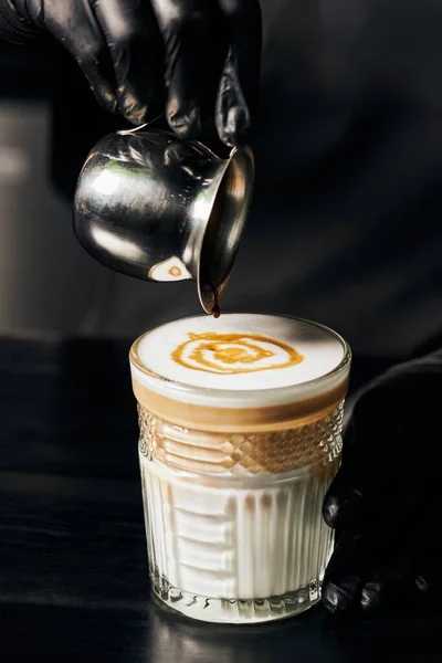 Barista preparing latte macchiato, pouring espresso in glass, pitcher with coffee, milk foam — Stock Photo
