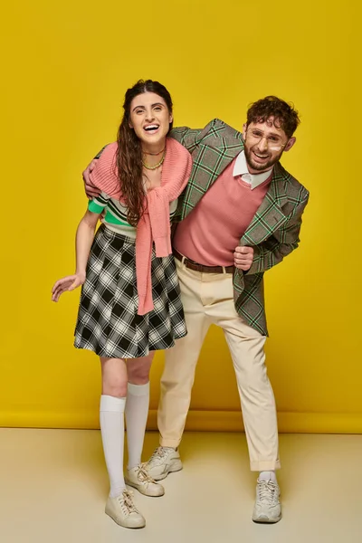 Junges Paar hat Spaß, Mann mit Brille umarmt junge Frau lachend vor gelbem Hintergrund, Studenten — Stockfoto