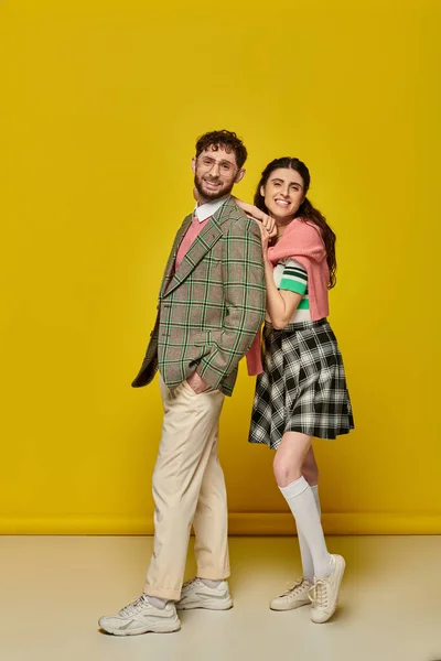 Glückliche Studenten, junge Frau lehnt an Mann mit Brille, College-Outfit, gelber Hintergrund, Paar — Stockfoto