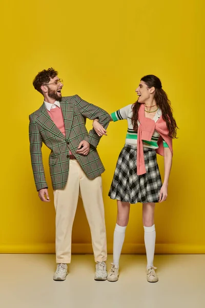 Estudantes engraçados, casal em pé no fundo amarelo, boca aberta, roupas da faculdade, desgaste acadêmico — Fotografia de Stock