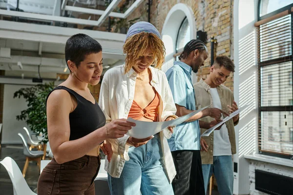 Multicultural colleagues looking at project on papers, coworking, startup, generation z people — Stock Photo