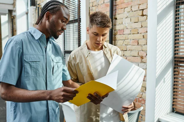 Young interracial men looking at project, colleagues, office workers, startup, generation z — Stock Photo