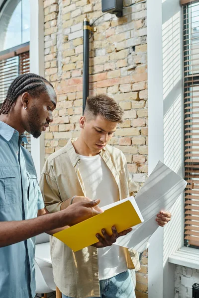 Multicultural men looking at project, young colleagues, office workers, startup, generation z — Stock Photo