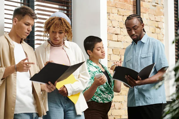 Gente de negocios interracial concentrada discutiendo proyecto de startup en oficina, coworking, carpetas - foto de stock