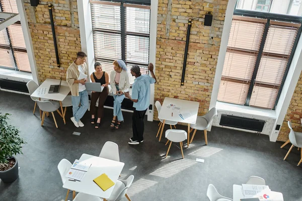 Des gens d'affaires multiculturels utilisant un ordinateur portable, partageant des idées, démarrage, coworking, open space, graphiques — Photo de stock