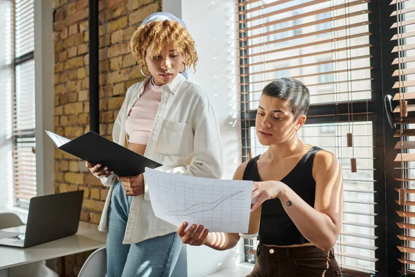 Young interracial women discussing project, startup, graphs, black woman with folder, gen z — Stock Photo