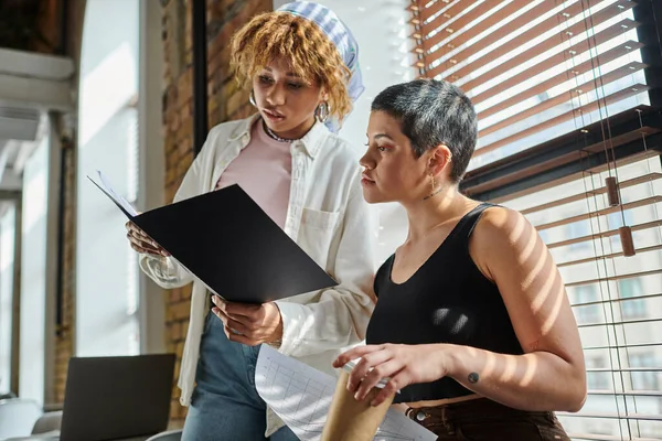 African american woman holding folder with documents, open space, startup project, ideas, colleagues — Stock Photo