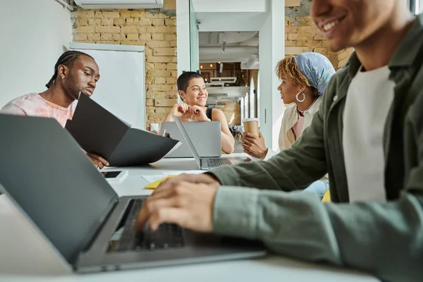 Happy team leader and diverse coworkers, interracial, coworking, startup, man using laptop, gen z — Stock Photo