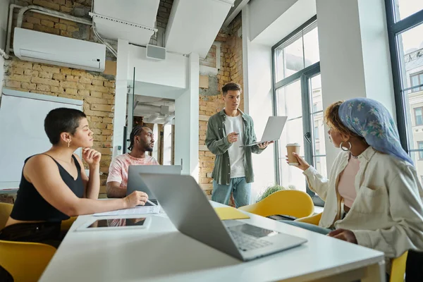 Manager discussing startup project with african american team leader and colleagues, coworking — Stock Photo