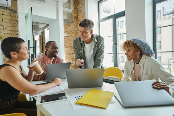 Diverse Geschäftsleute lächeln und diskutieren Startup-Ideen in der Nähe von Gadgets, Planung, Coworking — Stockfoto