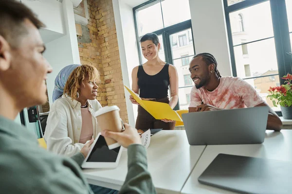 Coworking, feliz equipe interracial sorrindo no escritório, compartilhando ideias, usando gadgets, profissionais — Fotografia de Stock