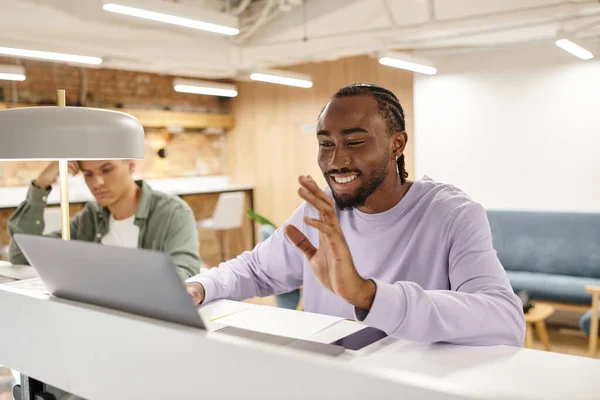 Coworking, happy african american man having video call, using laptop, startup, hello, generation z — Stock Photo