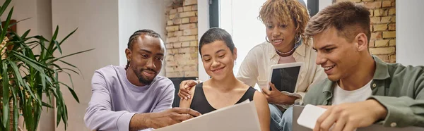 Happy interracial team holding gadgets, looking at startup project, sharing ideas, gen z, banner — Stock Photo
