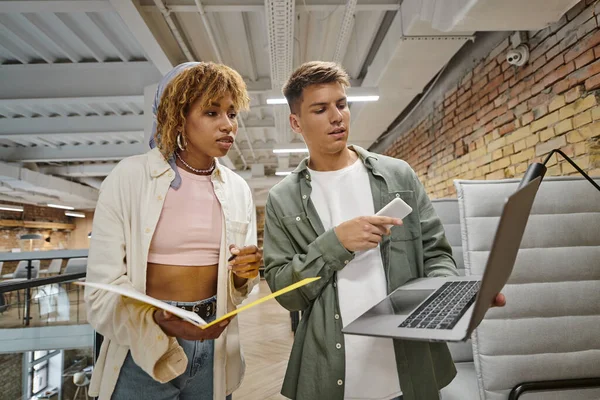 Young man showing project on laptop to african american woman, startup, planning, ideas, gen z — Stock Photo