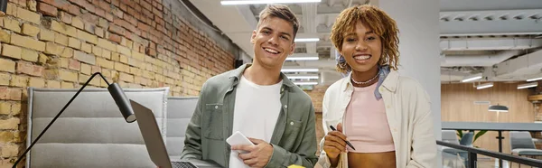 Happy interracial colleagues looking at camera, holding gadgets, startup, generation z, banner — Stock Photo