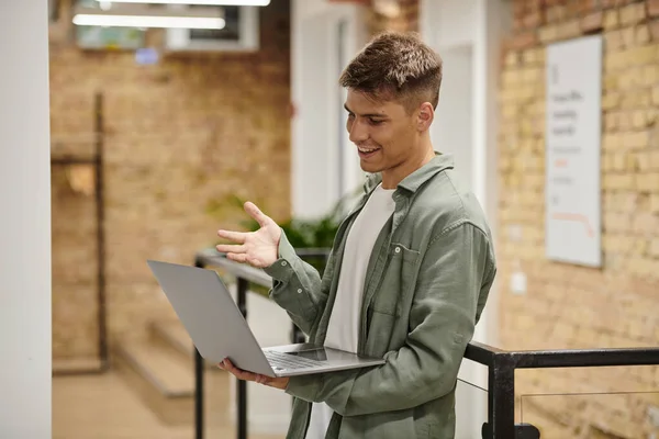Homem feliz usando laptop, chamada de vídeo, coworking moderno, ambiente de escritório, geração z, inicialização — Fotografia de Stock