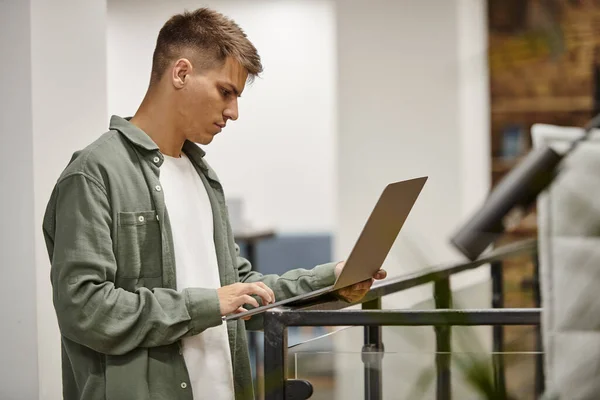 Young businessman using laptop, modern coworking, office environment, generation z, startup ideas — Stock Photo