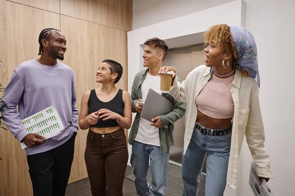 Diversidad cultural, hombres y mujeres interracial positivos caminando juntos en el coworking moderno, startup - foto de stock