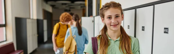 Banner, positivo teen girl guardando la fotocamera nel corridoio della scuola, volto felice, torna al concetto di scuola — Foto stock
