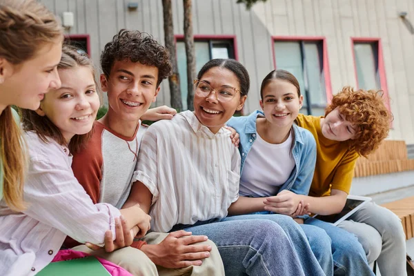 Positive african american woman holding hands with teen students, diversity, teacher, study — Stock Photo