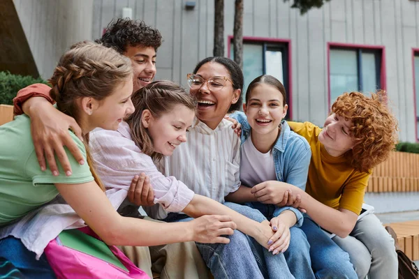 Heureuse femme afro-américaine étreignant avec des adolescents, diversité, professeur, étude, sourire — Photo de stock