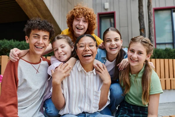 Diversité culturelle, retour à l'école heureux professeur afro-américain câlins avec les enfants adolescents, éducation — Photo de stock