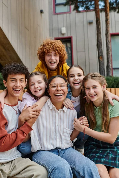 Cultural diversity, back to school happy african american teacher hugging with positive teenage kids — Stock Photo