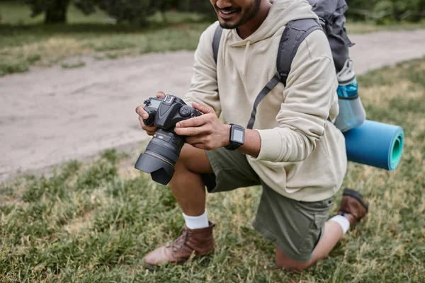 Abgeschnittene Ansicht glücklicher indischer Fotograf mit professioneller Kamera, natürliche Lage, Reise — Stockfoto