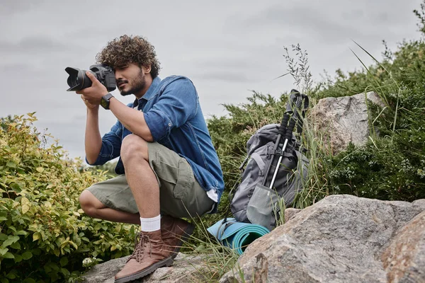 Viagem fotógrafo conceito, homem indiano feliz tirar foto na câmera digital durante a viagem, natureza — Fotografia de Stock