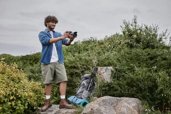 Concept d'aventure et de photographie, heureux homme indien prenant des photos à l'appareil photo dans un lieu naturel, bannière — Photo de stock