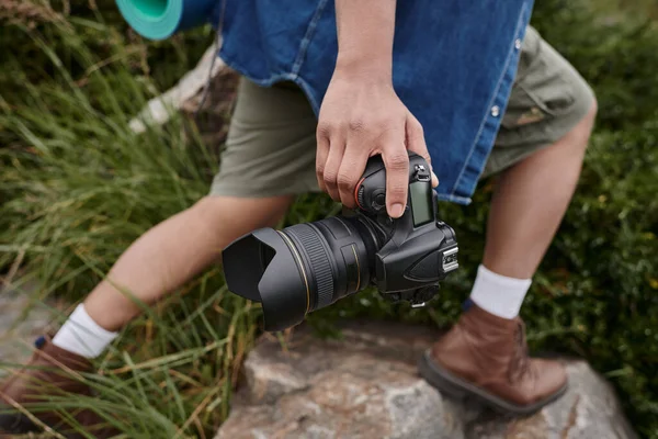 Conceito de viagem e fotografia, vista cortada do homem segurando câmera e em pé no lugar natural — Fotografia de Stock