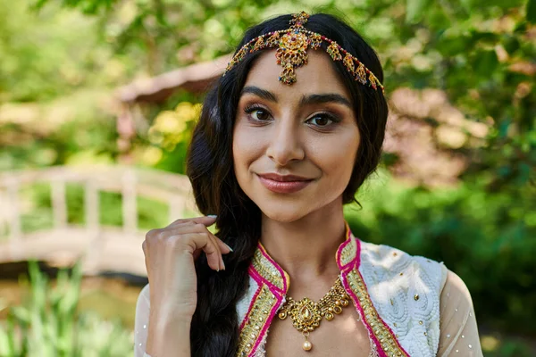 Porträt einer brünetten Indianerin in traditioneller Kleidung, die während eines sommerlichen Parkausflugs in die Kamera blickt — Stockfoto