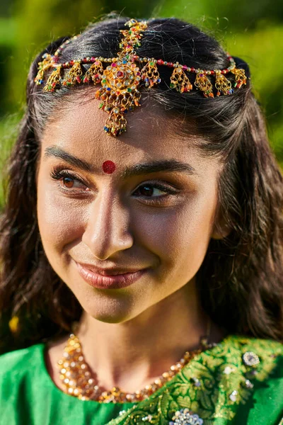 Portrait de jeune femme indienne souriante avec bindi et matha patti debout à l'extérieur — Photo de stock