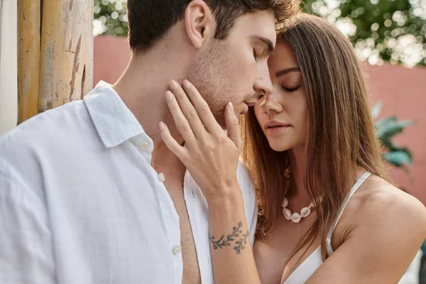 Bella donna toccando guancia di bel fidanzato durante le vacanze estive, prima momento bacio — Foto stock