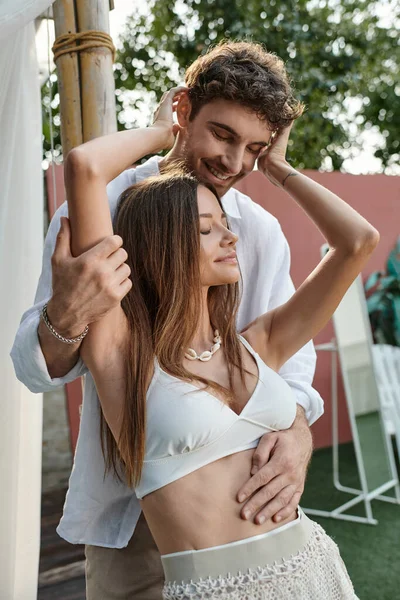 Mulher feliz com tatuagem abraçando namorado em traje de verão branco durante as férias, fuga romântica — Fotografia de Stock