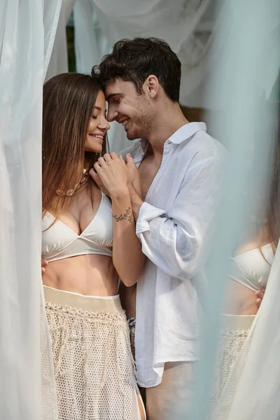 Alegre hombre sonriendo con hermosa mujer durante las vacaciones de verano, pareja romántica cogida de la mano — Stock Photo