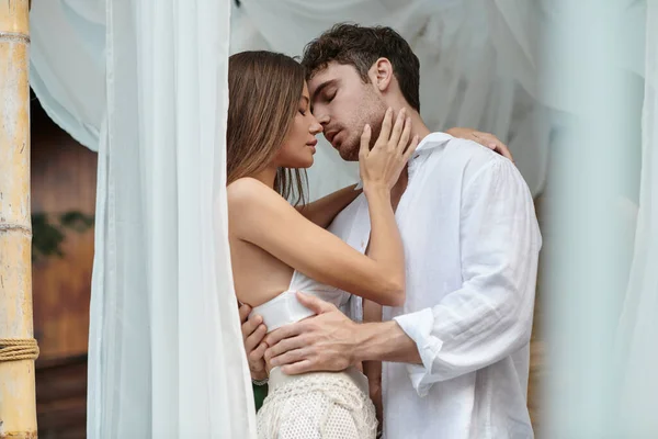 Zartes Paar vor dem Kuss, schöner Mann umarmt Frau in der Nähe von weißem Tüll des privaten Pavillons — Stockfoto
