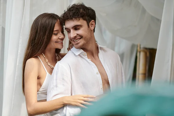 Feliz pareja, alegre hombre y mujer en ropa blanca sonriendo durante las vacaciones de verano - foto de stock