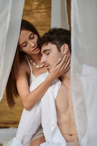 Couple romantique, belle femme touchant la joue de l'homme et assise dans un pavillon privé, séduction — Photo de stock