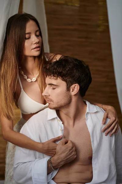 Романтическая пара, татуированная женщина, обнимающая красивого мужчину внутри частного павильона с белым тюлем — стоковое фото