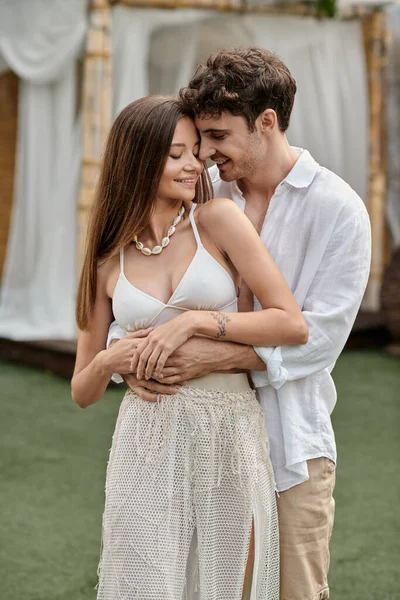 Handsome man hugging tattooed girlfriend in crop top and standing together outdoors, summer getaway — Stock Photo