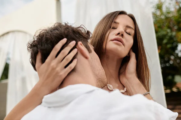 Retrato de hombre besando cuello de hermosa mujer durante la escapada romántica en verano, gesto amoroso - foto de stock