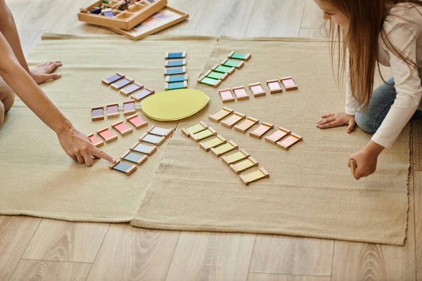 Materiale montessori, ragazza e insegnante vicino al gioco educativo a colori in forma di sole, educazione precoce — Foto stock