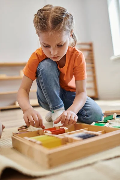 Montessori-Schulkonzept, Mädchen spielen farblich abgestimmtes Spiel und sitzen auf dem Boden, spielbasierte Methode — Stockfoto
