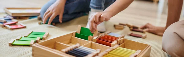 Montessori conceito de escola, vista cortada de menina jogando jogo de correspondência de cores perto do professor, banner — Fotografia de Stock